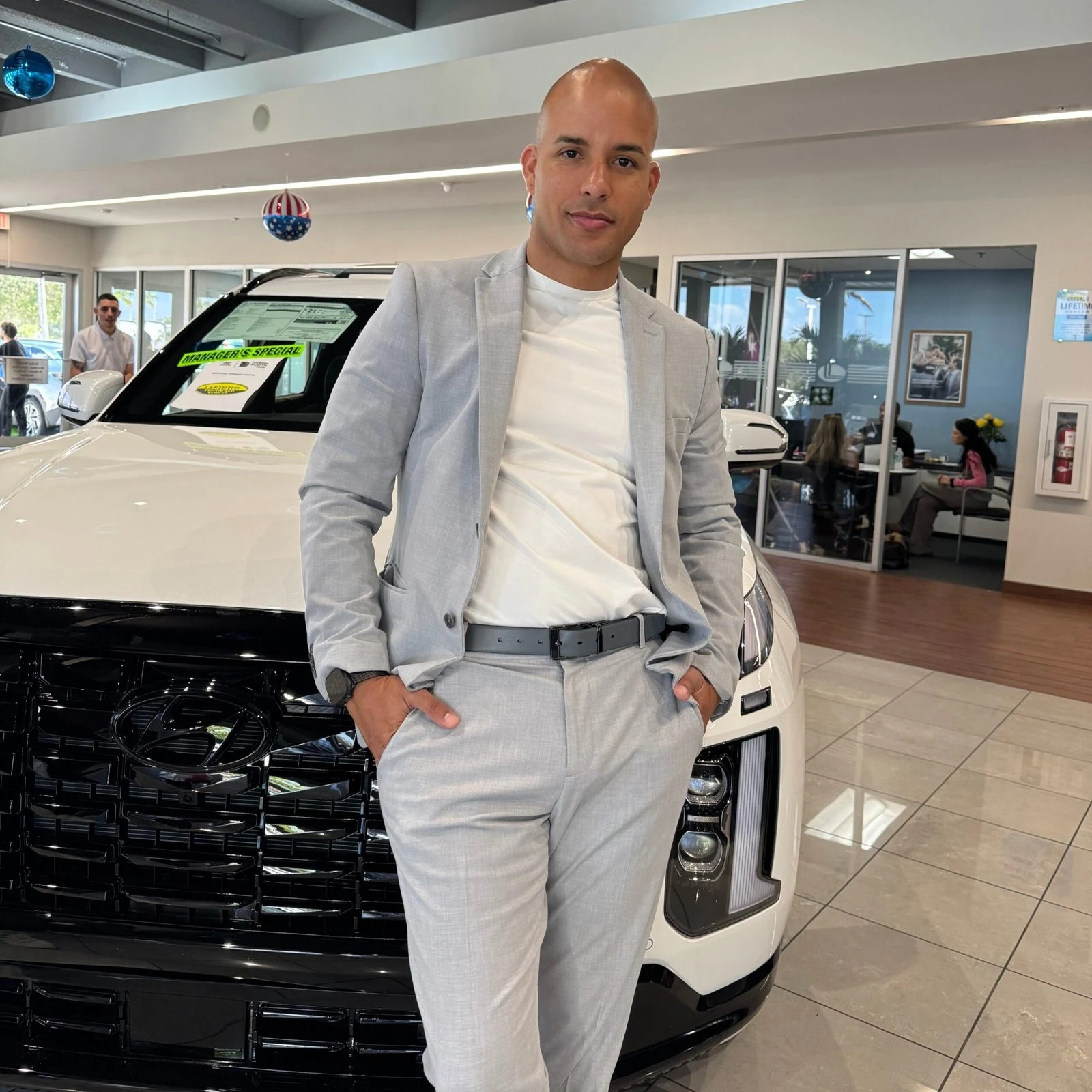 Karel en el showroom junto a un vehículo